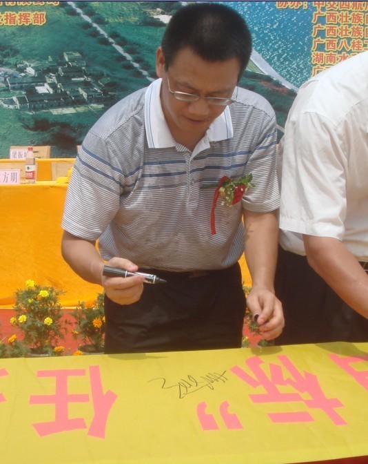 廣西新港灣公司副總經理姚方明在“奮戰(zhàn)100天，如期實現(xiàn)魚梁工程截流、通航、發(fā)電‘三大目標’”橫幅上簽字